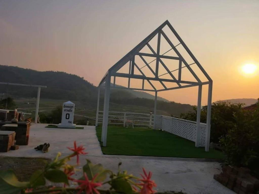a white pavilion with the sunset in the background at Ingmhok Resort in Suan Phung