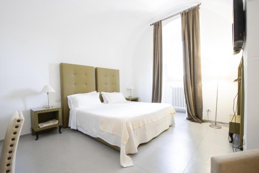 a bedroom with a white bed and a large window at Le Tre Sorelle in Bari