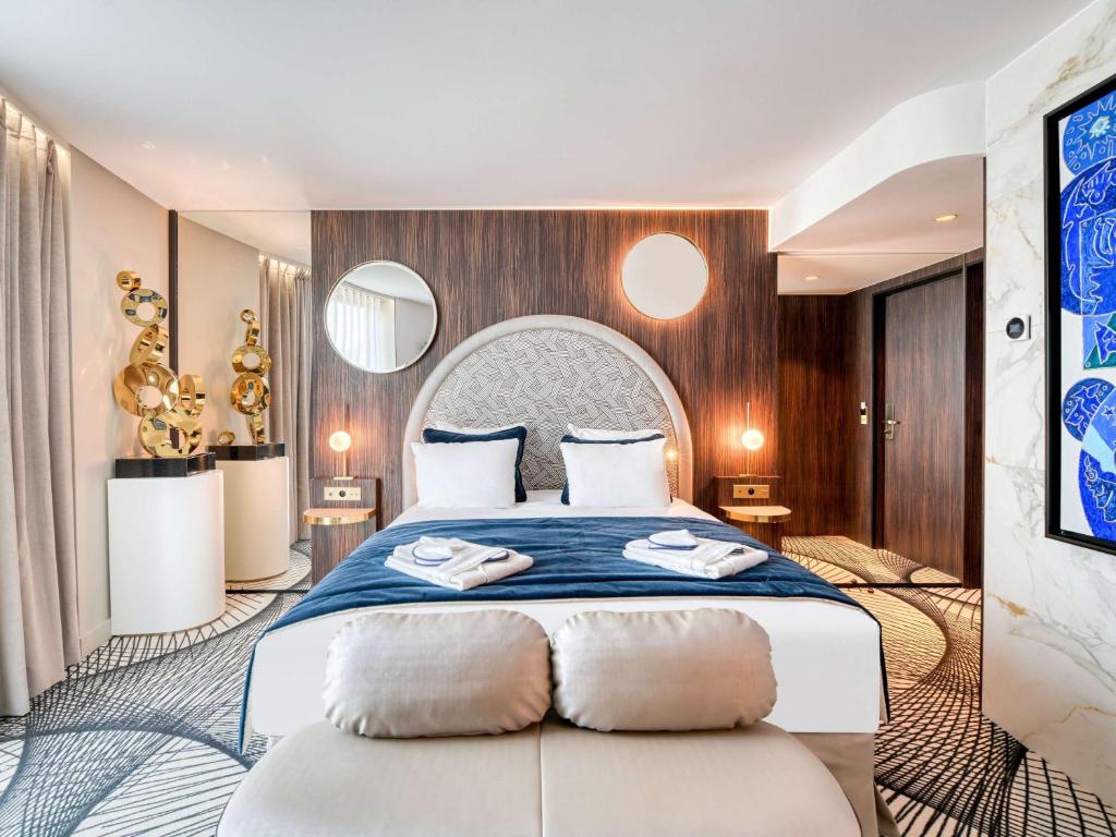 een slaapkamer met een groot bed en 2 handdoeken bij Novotel Paris Centre Bercy in Parijs