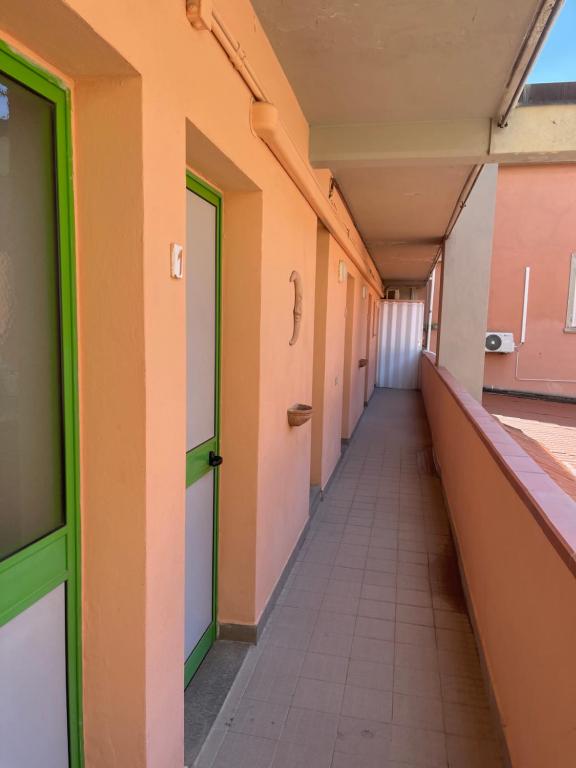 un couloir vide d'un bâtiment avec des portes et un couloir dans l'établissement Hotel Lupo di mare, à Marina di Castagneto Carducci