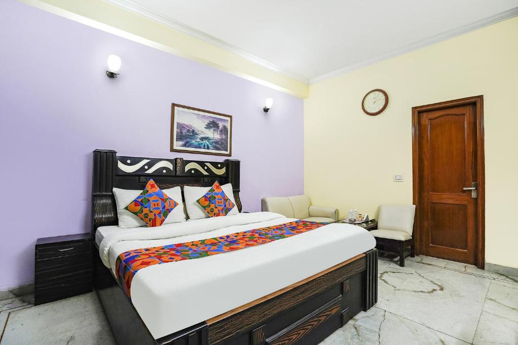 a bedroom with a large bed and a wooden door at FabExpress IVY Inn Sector 35 in Noida