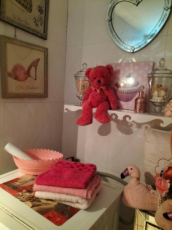 un oso de peluche rojo sentado en la parte superior de un estante en Chambre etoile, en Villeurbanne