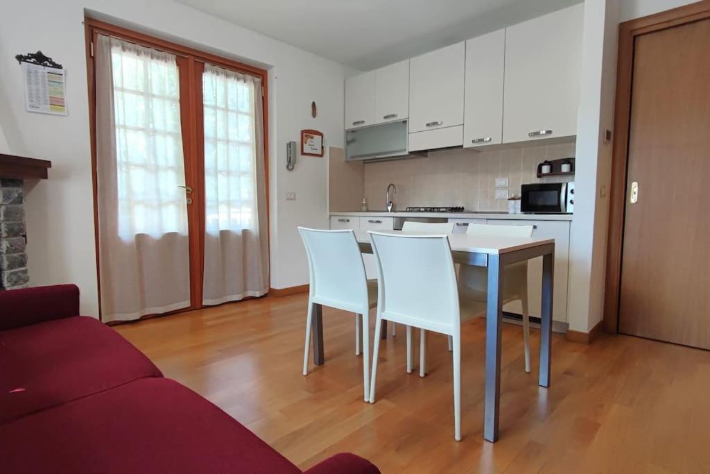 - une cuisine avec une table et des chaises dans le salon dans l'établissement Casa Vacanza Presolana con giardino e box auto, à Castione della Presolana