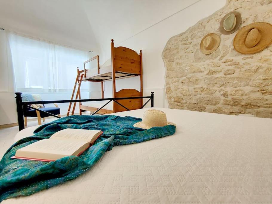 a bed with a blanket and hats on it at siciliacasevacanze - Pola Home in Marina di Ragusa