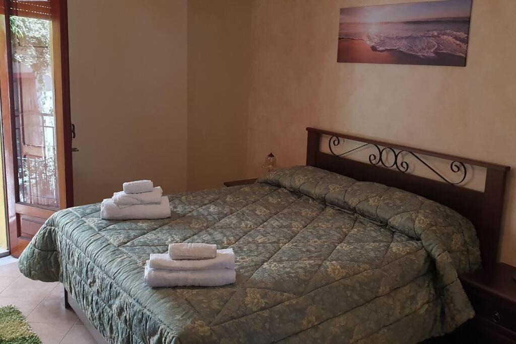 a bedroom with a bed with towels on it at Borgo San Giorgio Apartment in Castelmola