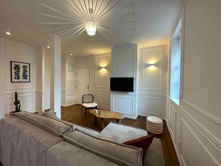 a bedroom with a large bed and a living room at Reims Cathedrale Centre Historique in Reims