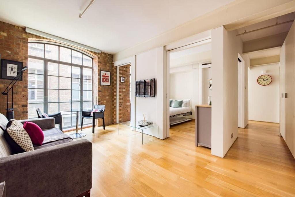 a living room with a couch and a bedroom at Central Soho Loft with A C & Concierge in London