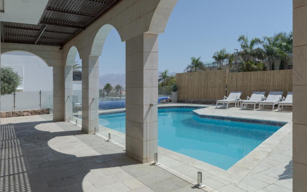 a swimming pool in a house with a patio at Villa Keshet Eilat in Eilat