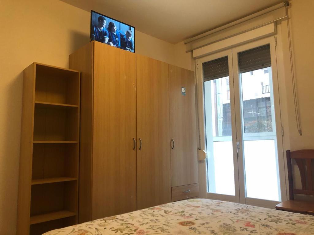 a bedroom with a bed and a cabinet with photographs on it at Apartamento San Gregorio in Pamplona