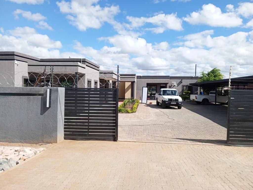 a garage with a gate in front of a building at Oakwood Guest House in Palatswe