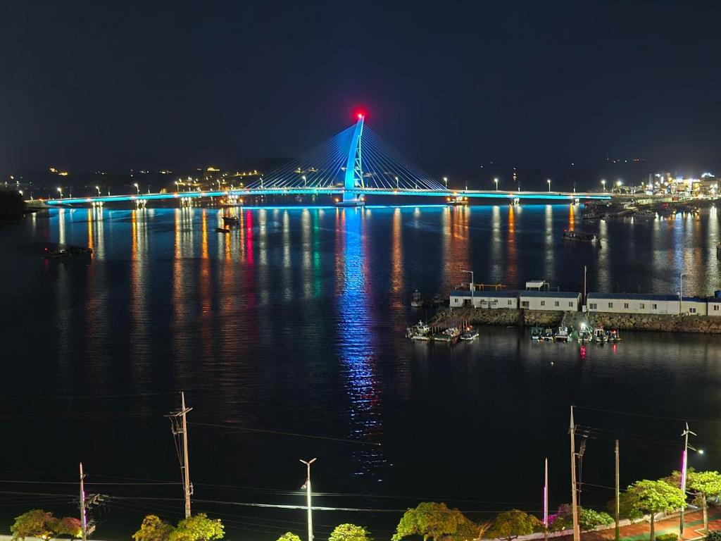 Yeosu Narsha Hotel في يوسو: جسر فوق الماء في الليل