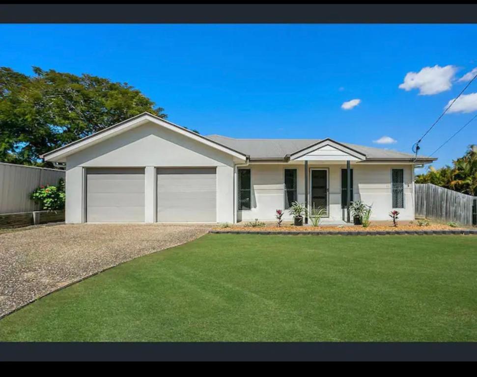 a white house with a large yard at Four bedroom large family home close to Ipswich city in Ipswich
