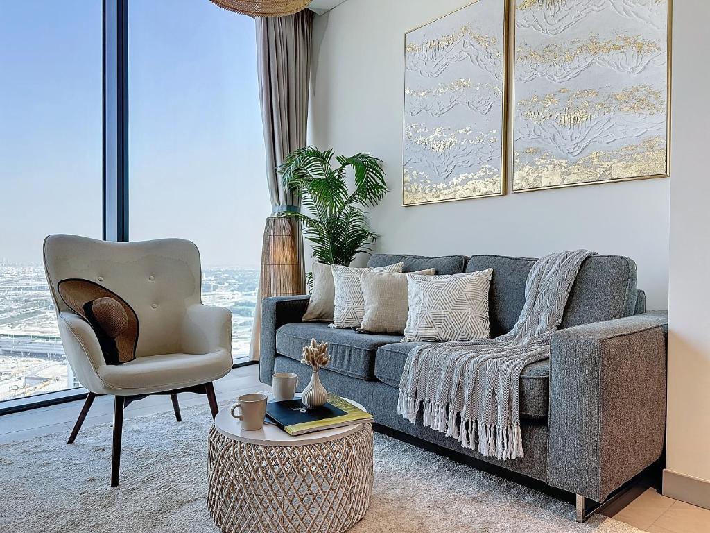 a living room with a couch and a chair at Key View - Sobha Waves in Dubai