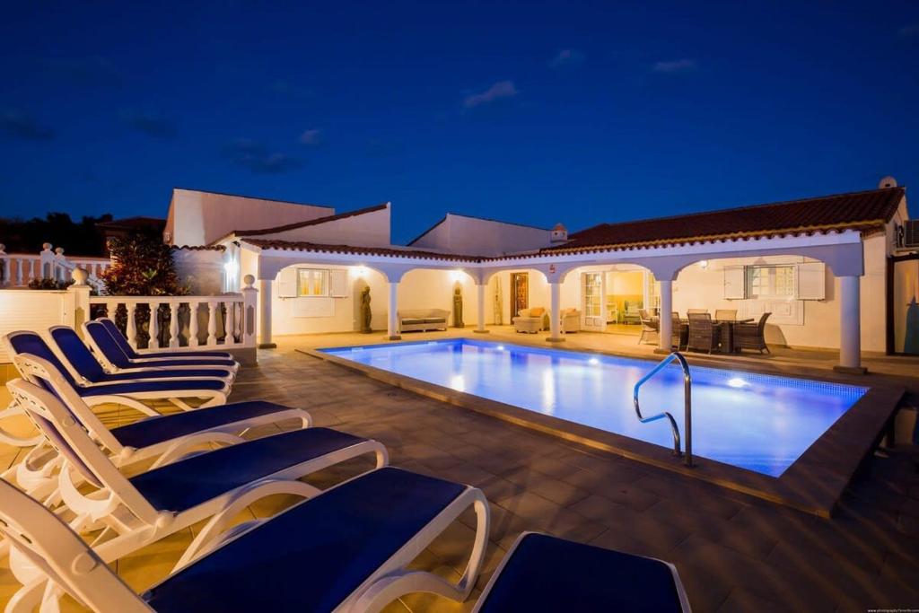 una piscina con tumbonas junto a una casa en Villa Freesia with heated pool and air conditionin en San Miguel de Abona