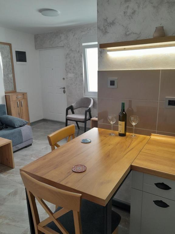a kitchen with a wooden table with two wine glasses at Nemanjina Centar in Pančevo