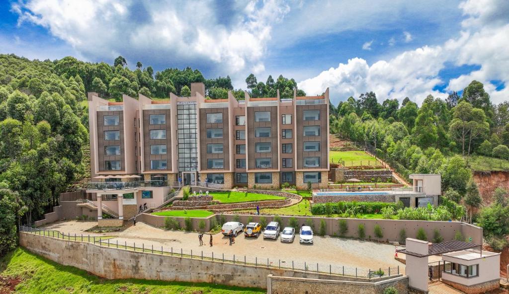 un gran edificio con coches estacionados frente a él en Humphreys HillHouse, en Kisii