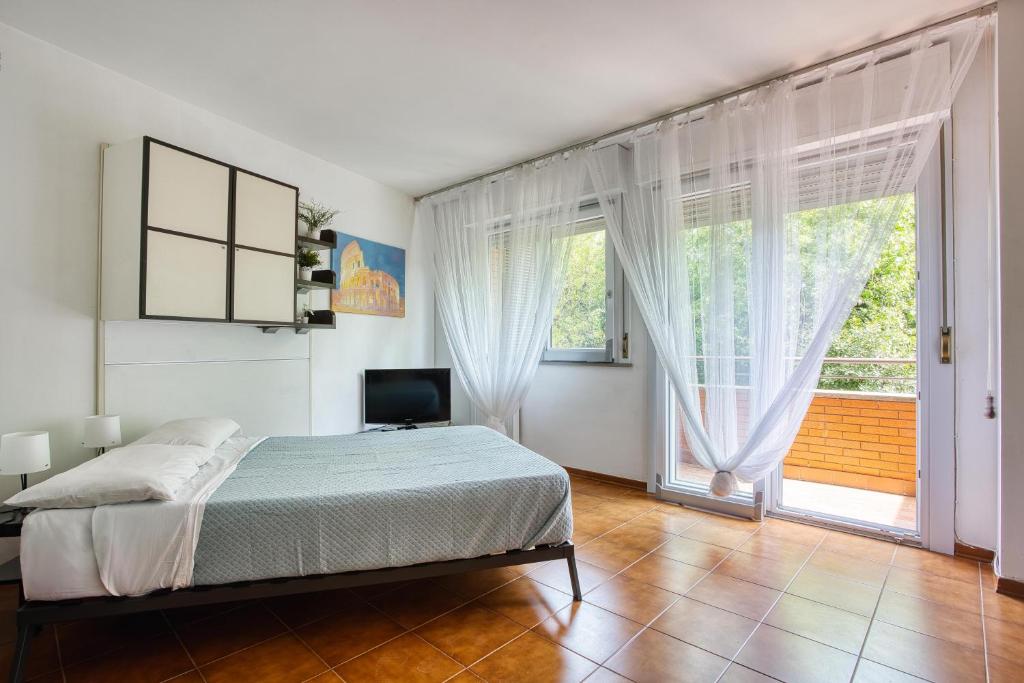 ein Schlafzimmer mit einem Bett und einem großen Fenster in der Unterkunft Domus Parnaso - Eur in Rom