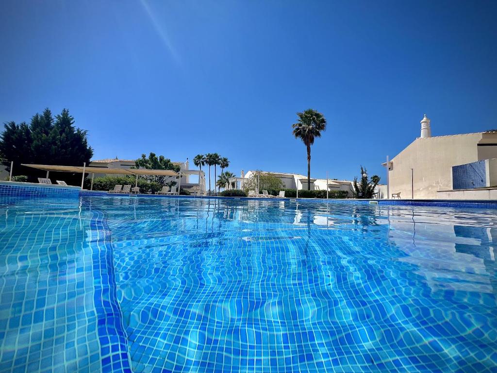 Una gran piscina con azulejos azules. en Vilamoura Eden Villa With Pool by Homing, en Vilamoura