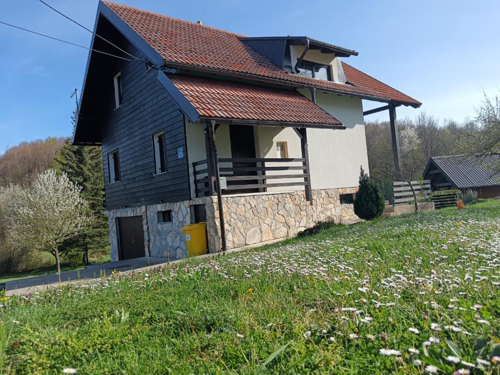 een huis met een rood dak en een grasveld bij Apartman Sveti Rok in Sveti Rok