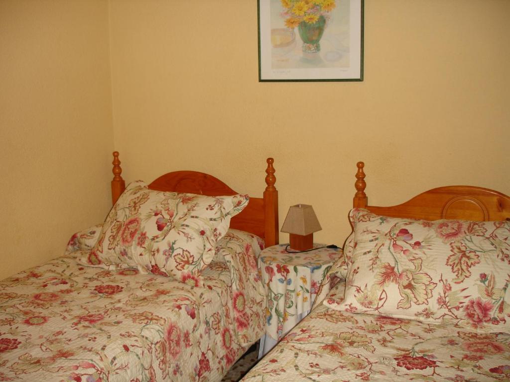 マドリードにあるHostal Puerta Bonita Vista Alegreのベッドルーム1室(ベッド2台付)が備わります。壁に絵が描かれています。