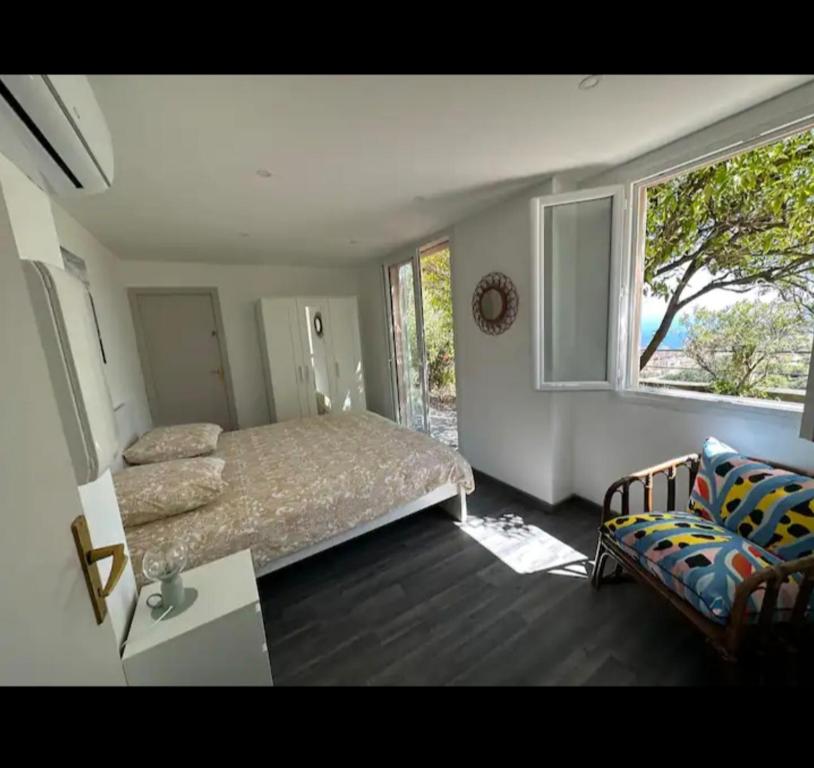 1 dormitorio con cama, sofá y ventana en 10 min de Monaco petite maison avec jardin vue mer et rocher de Monaco en La Turbie