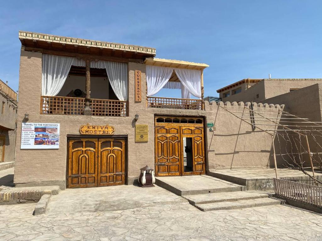 Edificio con 2 puertas de madera y balcón en MIRONSHOX GuEST HOUSE, en Khiva