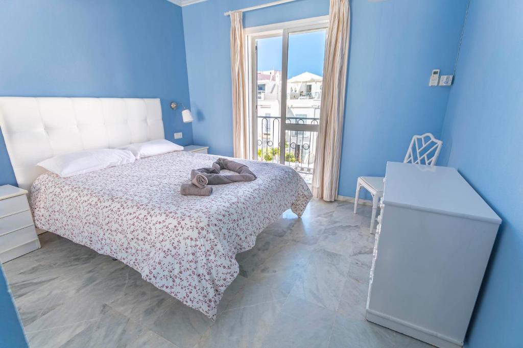 niebieska sypialnia z łóżkiem z butami w obiekcie Canovas Nerja - Casa adosada con piscina Los Huertos 6 w mieście Nerja