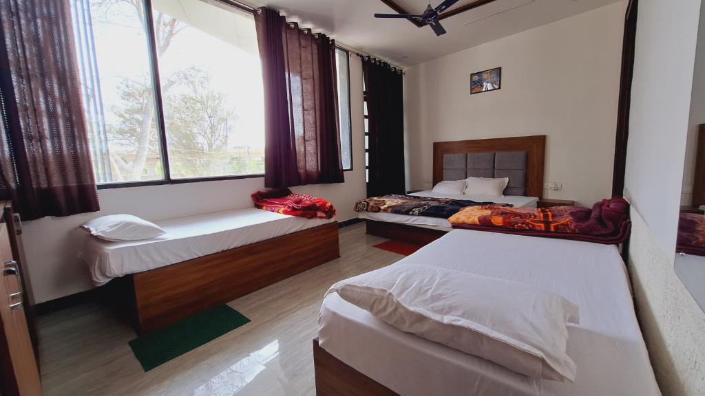 a bedroom with two beds and a window at Hotel MD Grand in Agra