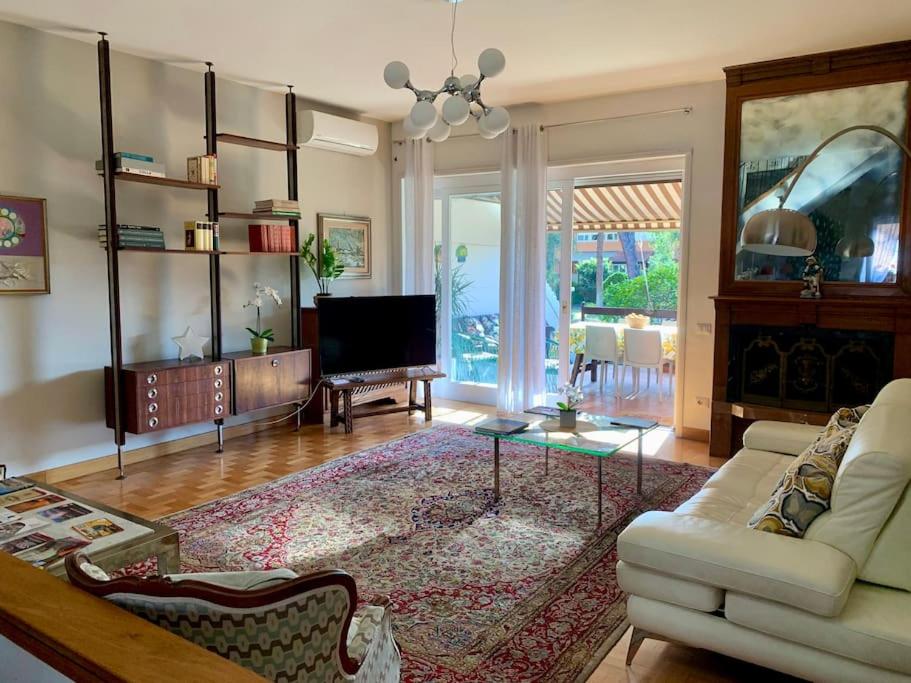 a living room with a couch and a tv at Charming elegant home in Casalpalocco, Roma ***** in Casal Palocco