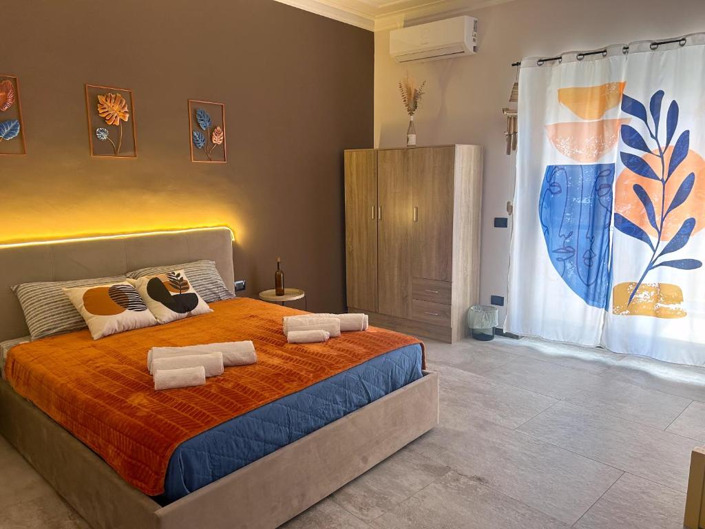 a bedroom with a bed with towels on it at Pura Vida Apartment in Catania