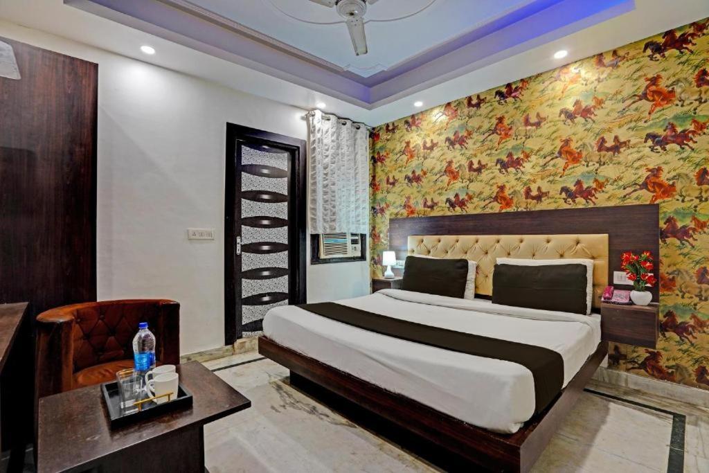 una camera da letto con un grande letto e carta da parati floreale di Hotel De Huespedes near international airport a Nuova Delhi
