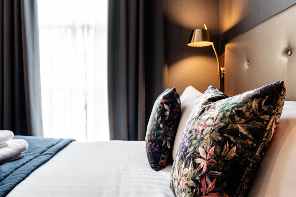 a bedroom with a bed with pillows and a window at The House on Warwick in London