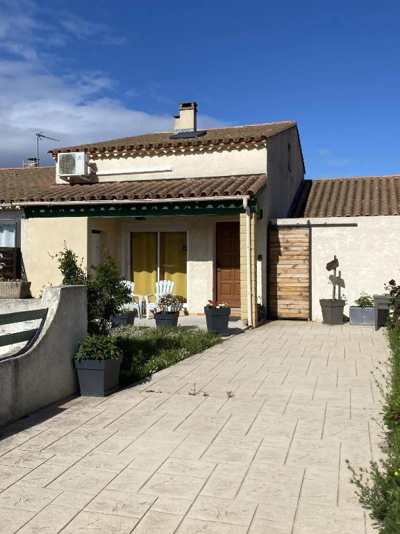 une maison avec une terrasse en face de celle-ci dans l'établissement Maison avec jardin à Sigean - Confort et tranquillité, à Sigean