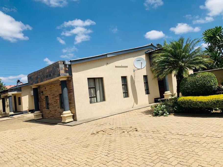 ein Gebäude mit einer Palme davor in der Unterkunft Perchment view Apartment in Lusaka