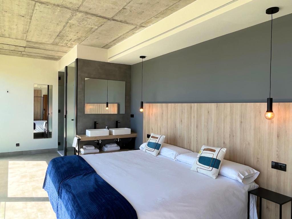1 dormitorio con 1 cama grande y baño en Hospedium Hotel Devalar Do Mar, en Camariñas