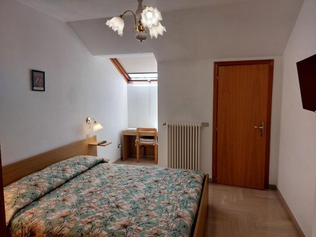 Schlafzimmer mit einem Bett, einem Schreibtisch und einer Tür in der Unterkunft Affittacamere Via Carducci in Gubbio