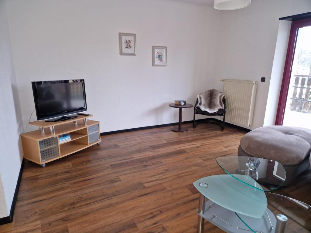 ein Wohnzimmer mit einem Flachbild-TV und Holzböden in der Unterkunft Ferienwohnung ca.80qm in Lebach