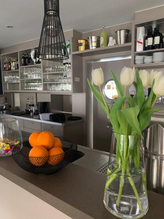 a kitchen with a vase of flowers and oranges at Pension zur Sonnenalb in Sonnenbühl