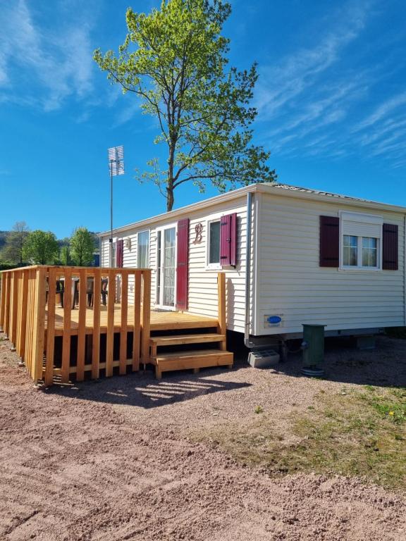 a mobile home with a porch and a wooden deck at Camping Mayet-de-Montagne in Le Mayet-de-Montagne