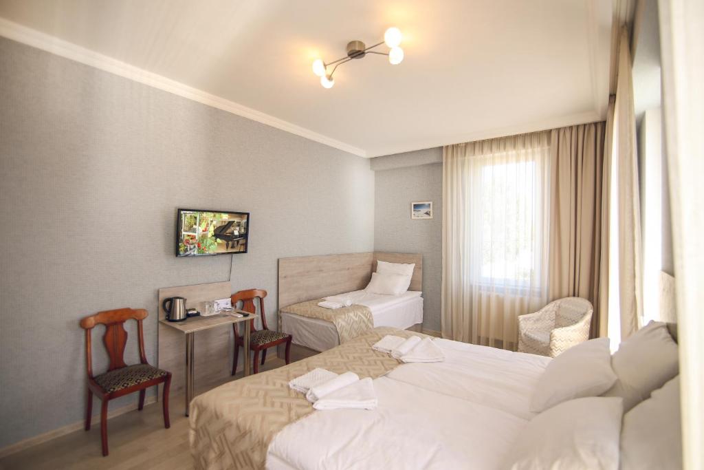 Postel nebo postele na pokoji v ubytování Kenari Hotel