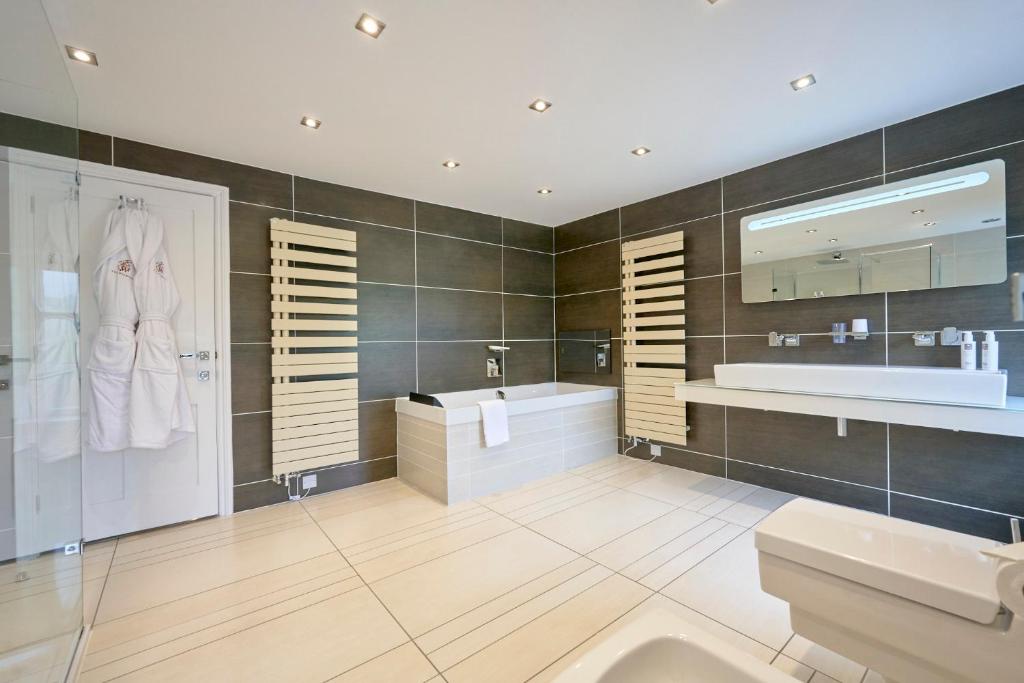 een badkamer met een bad, een wastafel en een spiegel bij Wilding Hotel in Brough