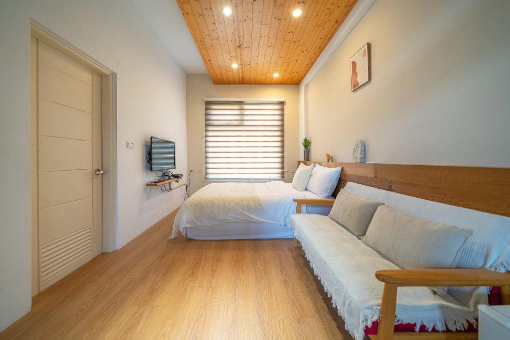 a bedroom with two beds and a couch in it at Field Trail Homestay in Jiaoxi