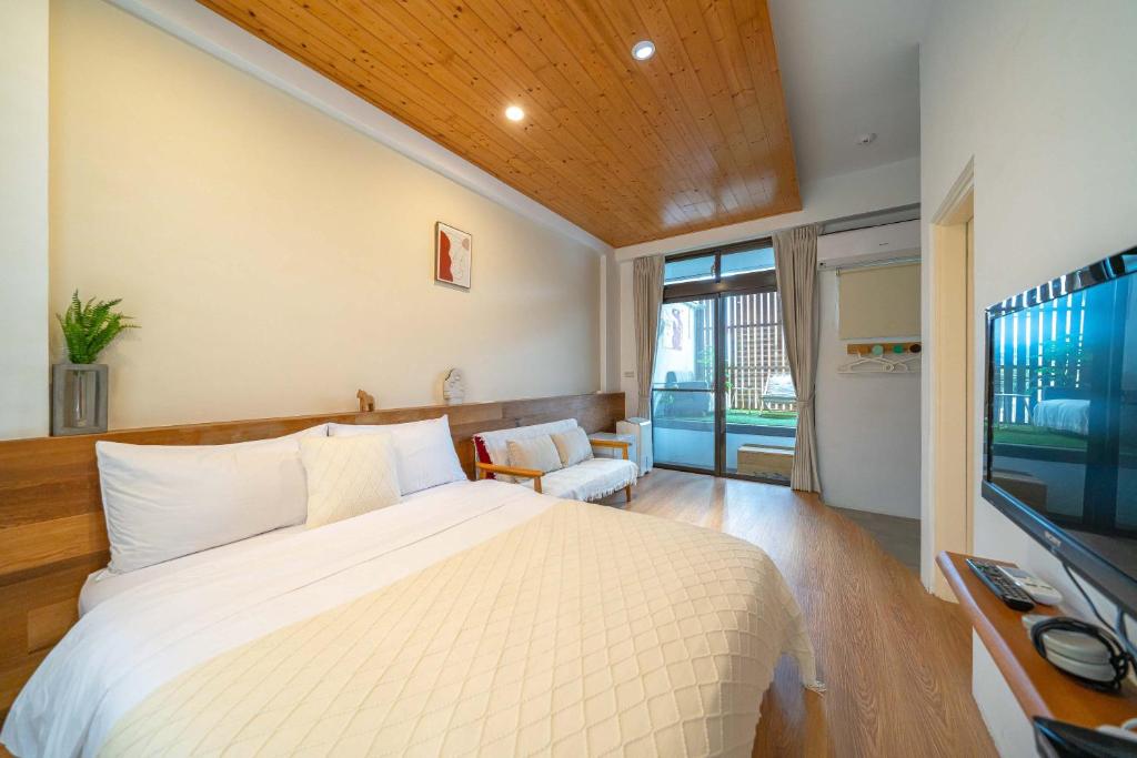a bedroom with a large bed and a large window at Field Trail Homestay in Jiaoxi