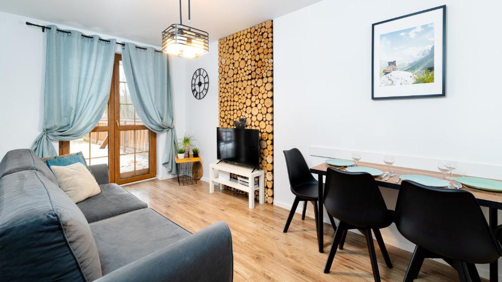 a living room with a couch and a dining room table at RentPlanet - Apartamenty Leśny Dom in Karpacz