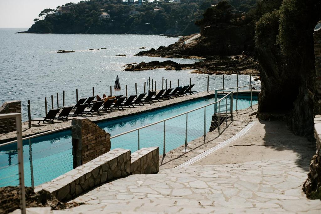 una piscina junto a un cuerpo de agua en Parc et Résidence le Provençal, en Hyères