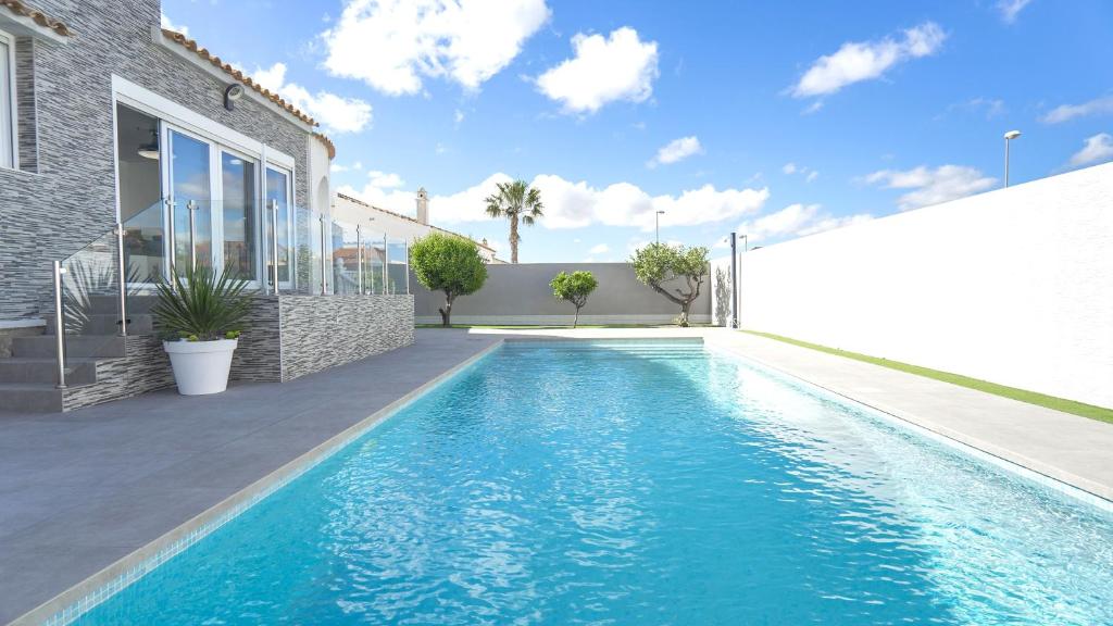 una piscina frente a una casa en Modern Detached 4 Bed 3 Bath Villa with private pool close to all amenities, en Villamartin