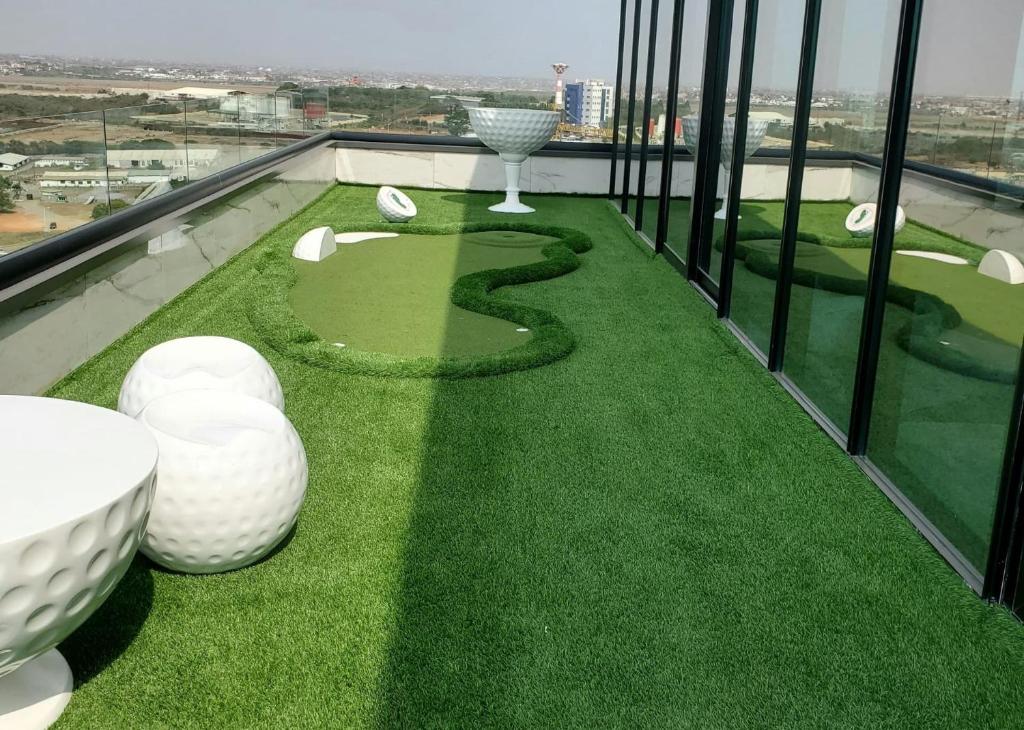 - un balcon avec un parcours de golf sur la pelouse dans l'établissement Cozy Ghana Airport Studio at Kass Towers, à Accra