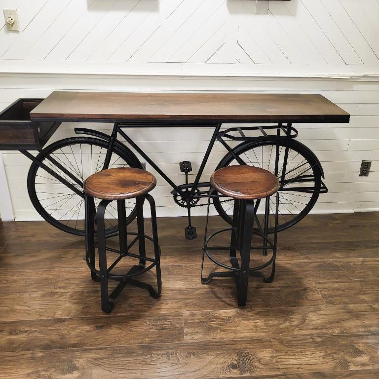 a wooden table with a bike with two stools at A Princely Experience! in Stoughton