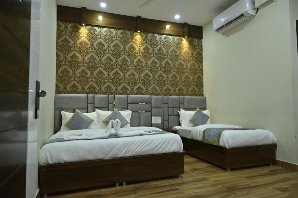 a bedroom with two beds and a wall at GUNTAS RESIDENCY in Amritsar