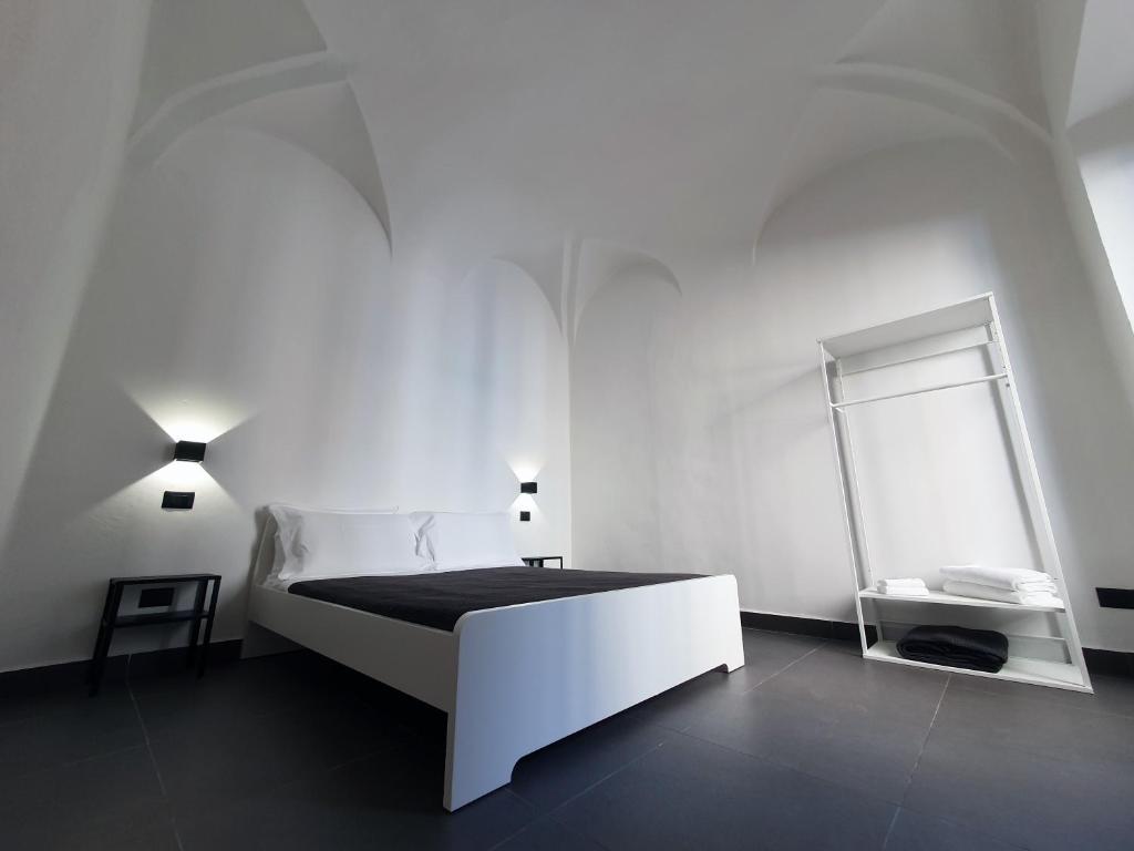 um quarto branco com uma cama branca e um espelho em Sant'Agostino XXXII em La Spezia